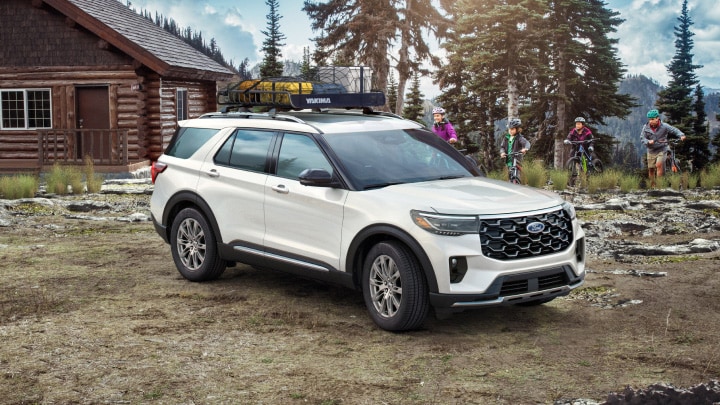 Ford Explorer con estabilización contra vientos laterales estacionada frente a una cabaña