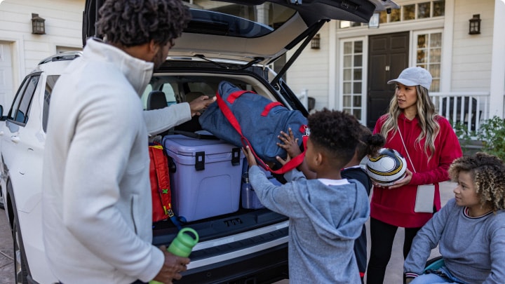 Familia ordenando el amplio baúl de su Ford Explorer