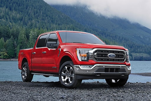 Ford F-150 híbrida en color rojo estacionada a la orilla de un lago